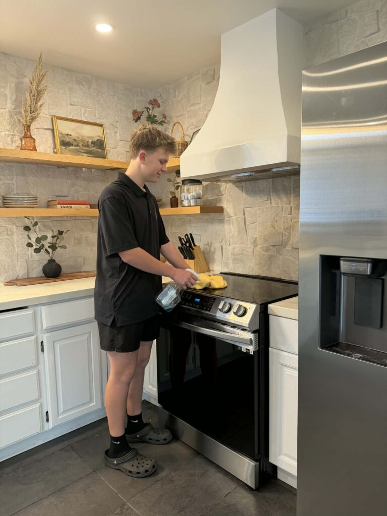 Three Trees Team Member cleaning a stove | Vacation Rental cleaning in Grants Pass, Oregon